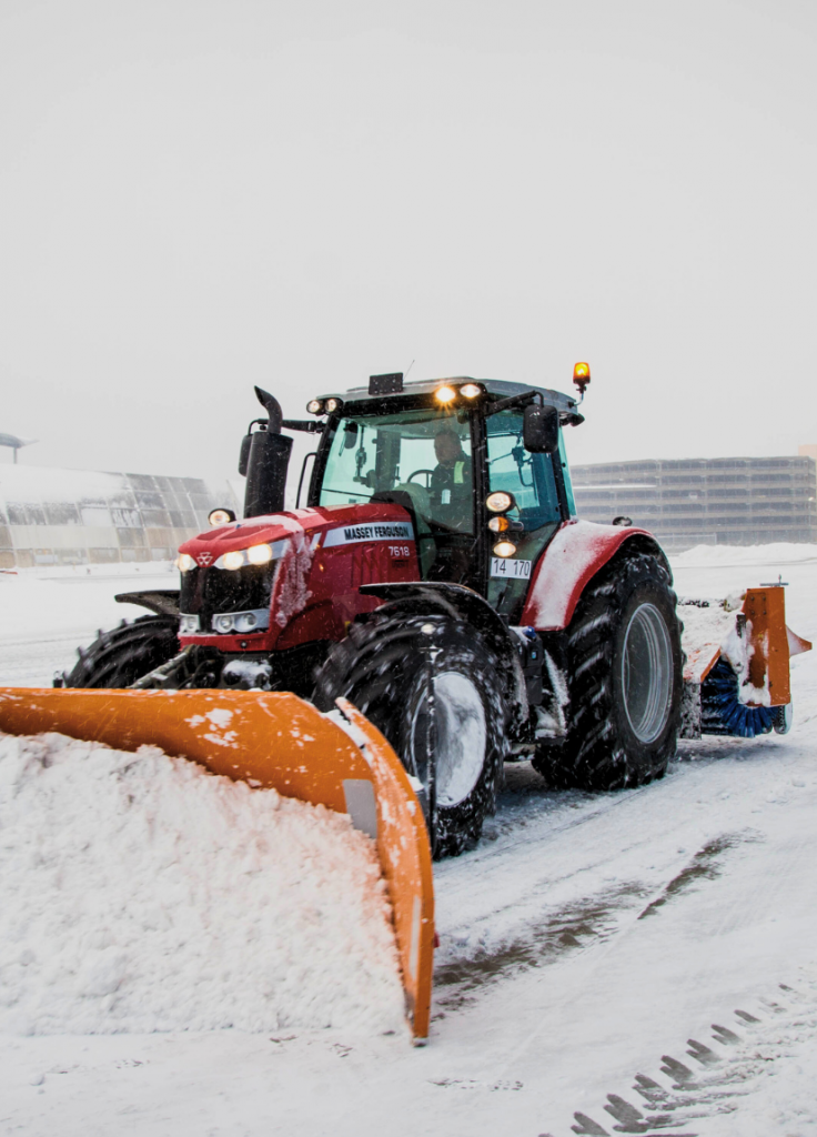 Ein Traktor mit Schneeschild beim Räumen