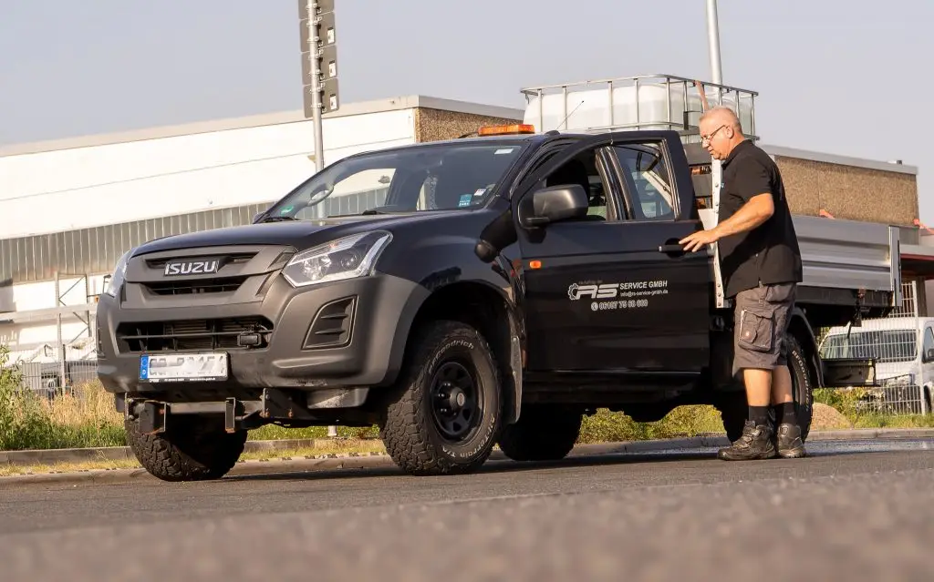 Mitarbeiter steigt in einen Pick-Up