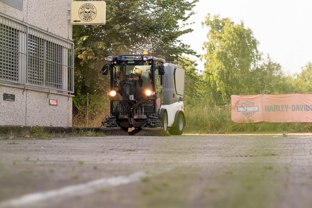Kehrmaschine fährt über Parkplatz